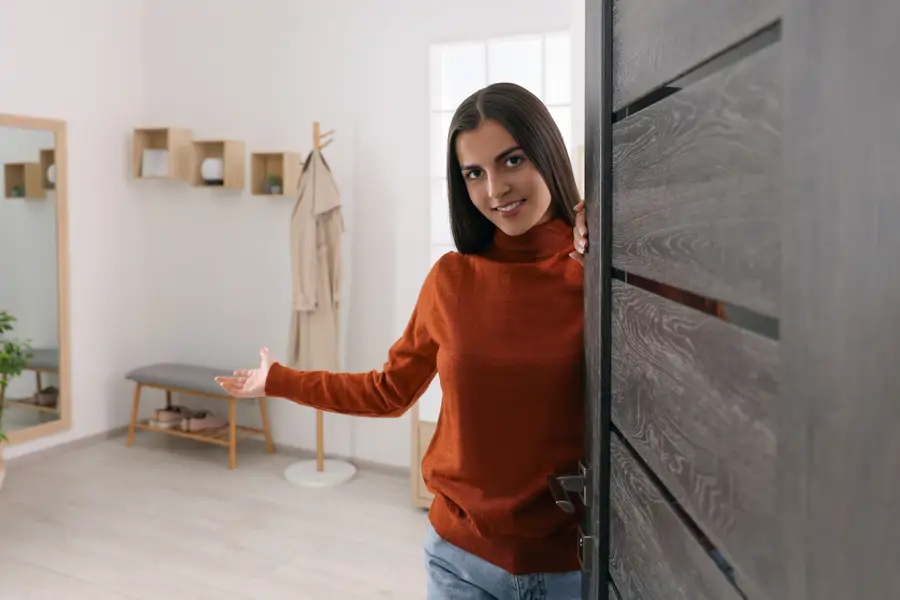Mujer que abre la puerta de su casa a invitados
