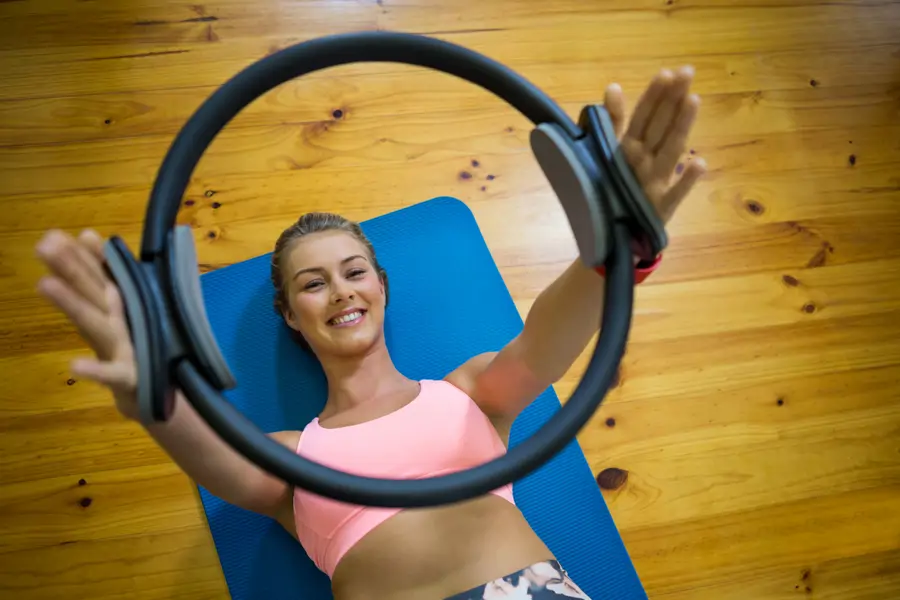 Estirar los brazos con aro de Pilates