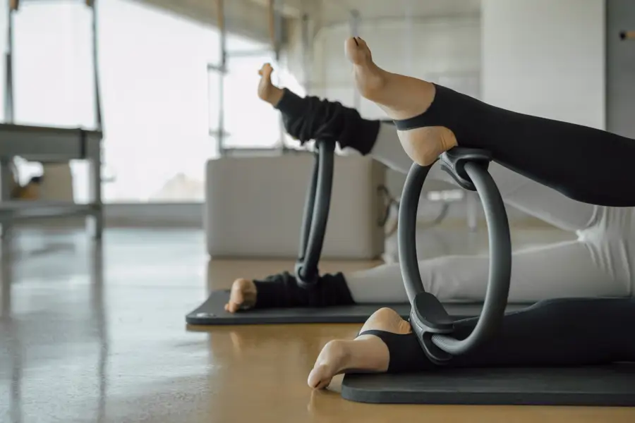 presión de aro de Pilates con los tobillos