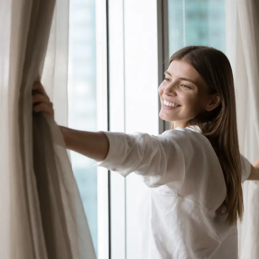 mujer abriendo cortinas